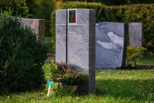 Besonderer Grabmal mit Kreuz und Licht in dunkel grau