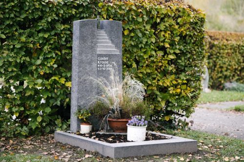 Handwerklicher dunkler besonderer Grabstein mit Treppe Urnengrabmal